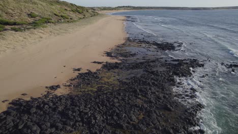 Isla-Phillip-Con-Mujer-Turista-Caminando-Por-La-Orilla-En-Victoria,-Australia---Toma-Aérea-De-Drones