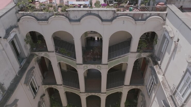Filmato aereo al rallentatore che sorvola il tetto di un edificio per rivelare il Palazzo dello Spagnolo a Napoli, Italia