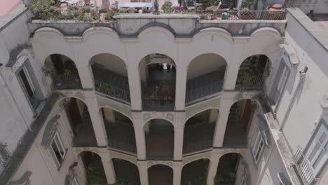 slow motion aerial footage flying over roof of building to reveal palazzo dello spagnolo to naples, italy.