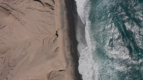 Aerial:-Birds-eye-view-of-Vlychada-beach-in-Santorini,-Greece-on-windy-day,-4K-prores