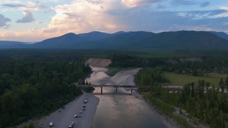 camping disperso junto al puente blankenship a lo largo del río al atardecer en montana, ee.uu.