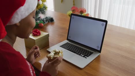 Fröhliche-Afroamerikanische-Plus-Size-Frau-Mit-Weihnachtsmütze,-Die-Zu-Weihnachten-Einen-Videoanruf-Mit-Einem-Laptop-Tätigt