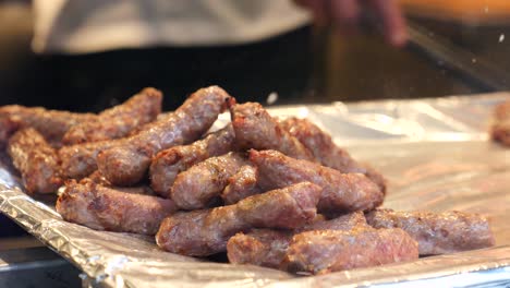 close up of grilled sausages on a foil lined tray