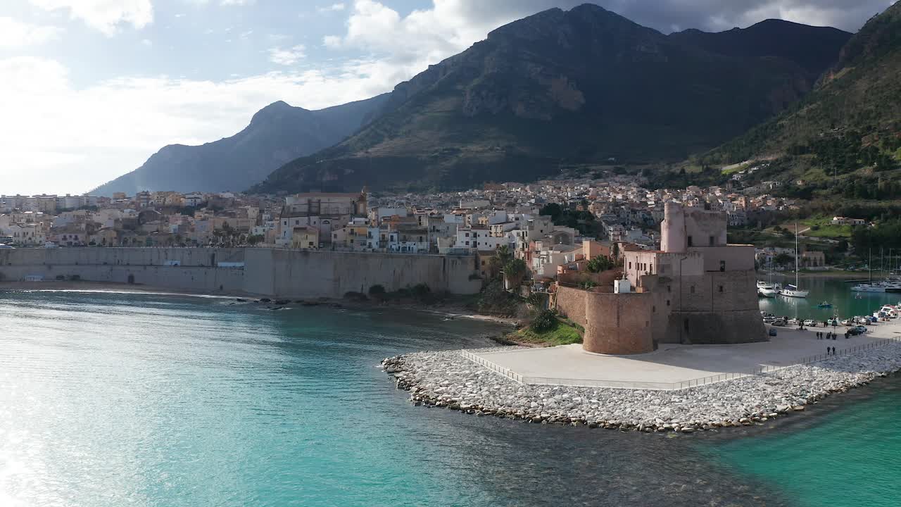 Aerial Flying Over Turquoise Waters In The Gulf Of Castellammare Towards Castello Arabo Normanno On Sunny Day