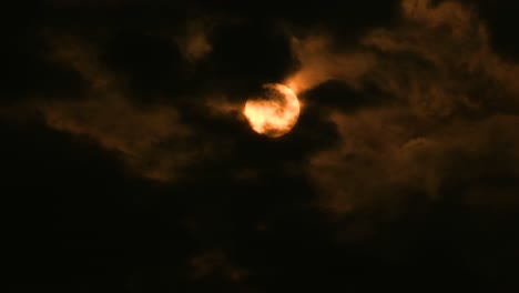 Yellow-Moon-or-Sun-Seen-through-Patches-of-Dark-Clouds-Moving-in-the-Wind
