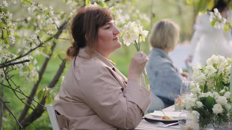 Hochzeitsfeier-Im-Garten-Am-Frühlingstag.-Der-Weibliche-Gast-Bewundert-Die-Blumendekoration