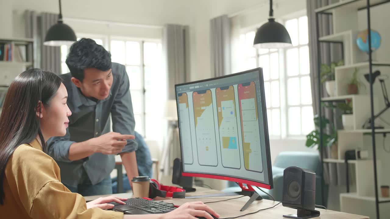 Asian Female Ux Architect Has Discussion With Male Design Engineer, They Work On Mobile Application In Office