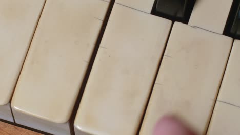 push in on fingers playing a chord on a piano