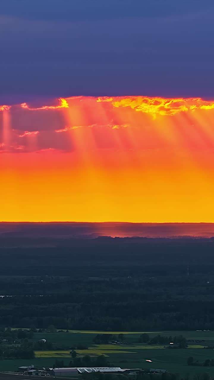 Farbenfroher Sonnenuntergang mit dramatischen Wolken in ruhiger, friedlicher Landschaft, Zeitraffer.