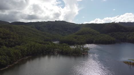 Flying-over-water-towards-a-peninsula-and-hills