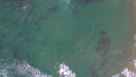 vertical slow moving drone footage of waves along te coast at point lonsdale, victoria, australia