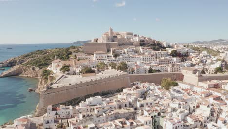 Aerial-view-of-Ibiza-city,-the-Old-Town-and-the-city-walls-of-Eivissa,-in-the-island-of-Ibiza,-on-a-sunny-and-clear-day