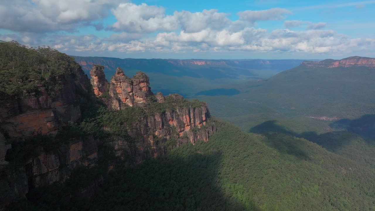 tres hermanas montañas azules dron aéreo katoomba sydney nsw australia punto de eco mirador acantilado caminar patrimonio mundial parque nacional árbol de goma bosque de eucalipto día soleado azulado nubes hacia arriba movimiento