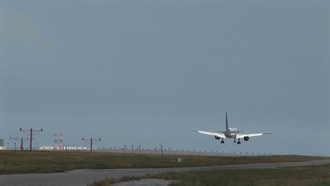 wide shot of  jet airplane lands on an airport runway