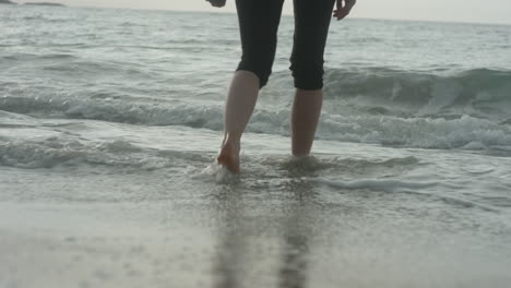 Close-up-of-Feet,-Pretty-Blonde-Girl-Walking-Barefoot-into-the-waves-at-the-Beach,-Bleik,-Lofoten-Islands,-Norway,-Beautiful-Sunset-Atmosphere