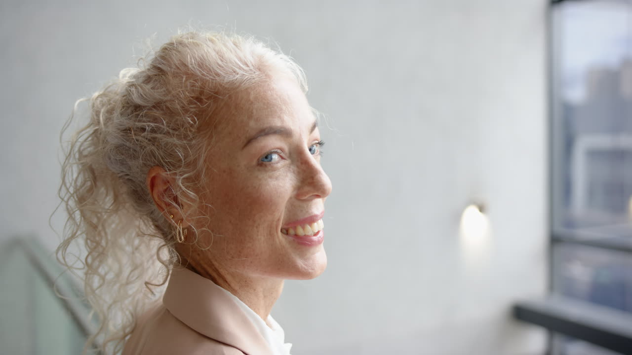 Smiling woman with curly hair looking away, appearing happy and content, copy space
