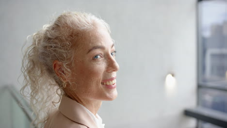 smiling woman with curly hair looking away, appearing happy and content, copy space
