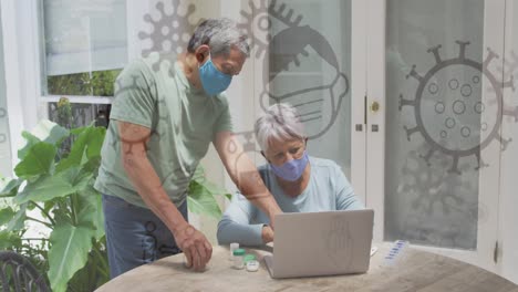 animación de iconos de covid 19 sobre una pareja mayor usando una computadora portátil con máscaras faciales