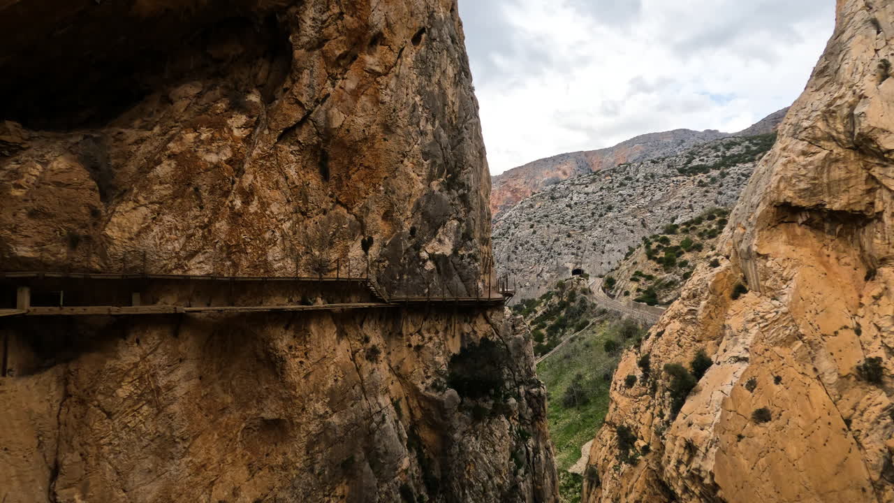 toma 4k de un puente de madera al lado de un acantilado de montaña en el caminito del rey en gorge chorro, provincia de málaga, españa