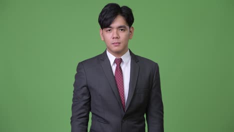 young handsome asian businessman pointing to camera