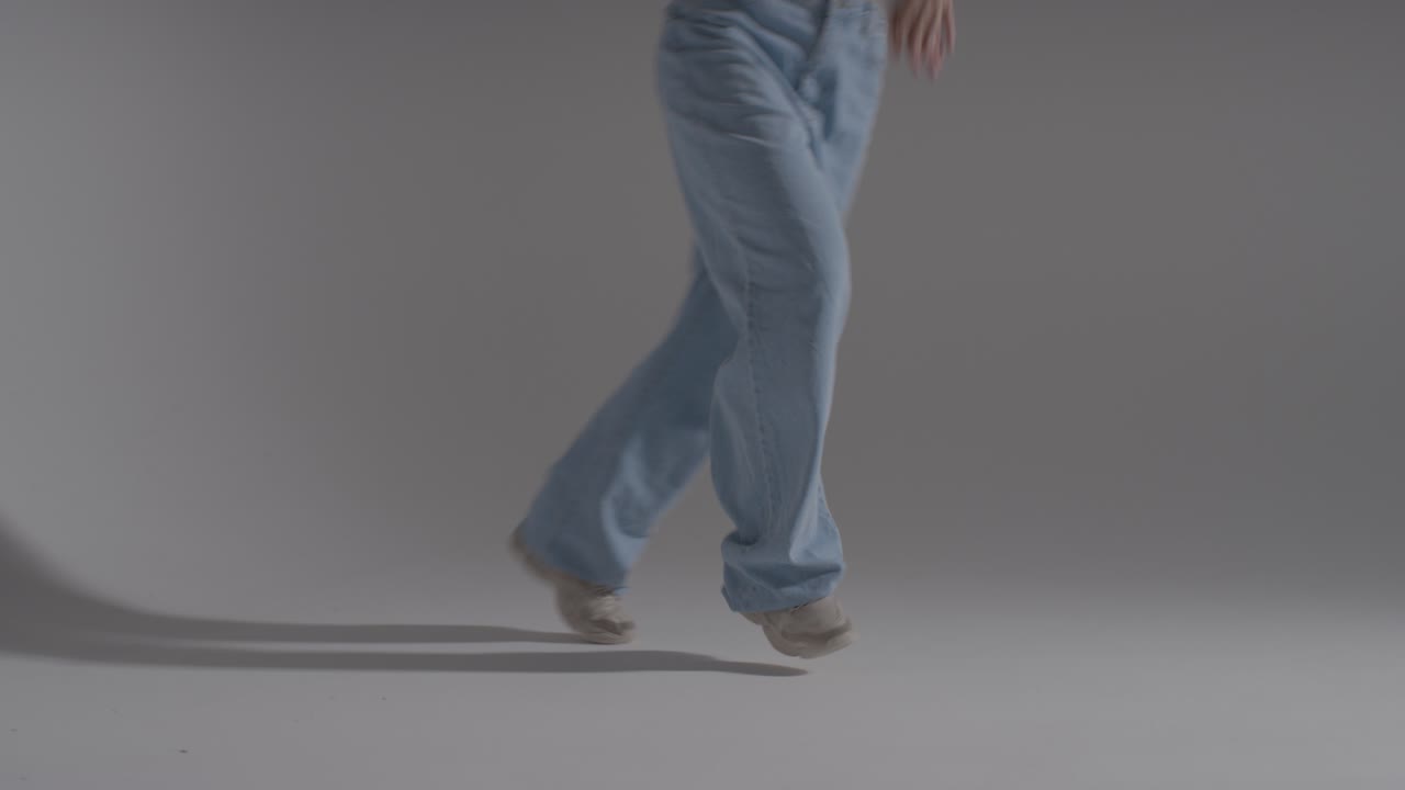 cerrar las piernas y los pies de una mujer divirtiéndose bailando contra el fondo blanco del estudio 1