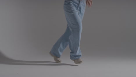 close up on legs and feet of woman having fun dancing against white studio background 1