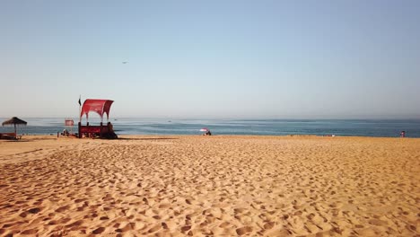 playa de villamoura en el algarve portugal con estación de socorrista y sombrilla solitaria acercándose al final del día