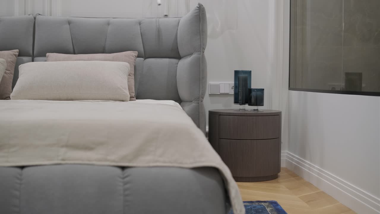 dormitorio de lujo con un cabecera de tuft y baño integrado con una bañera independiente y espejo iluminado