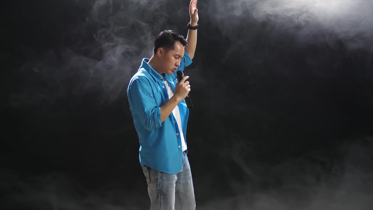 무대에서 마이크를 들고 노래하는 남자