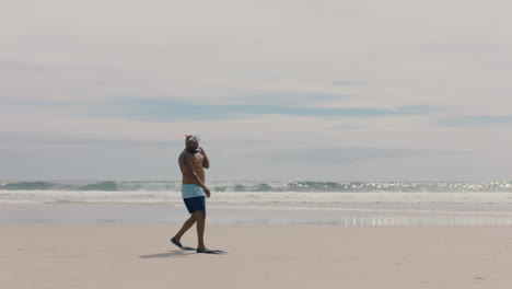 funny african american man walking on beach wearing flippers getting ready to swim enjoying summer by sea 4k