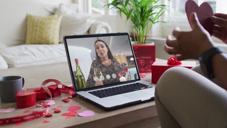 Happy-caucasian-woman-with-wine-making-valentine's-day-video-call-on-laptop