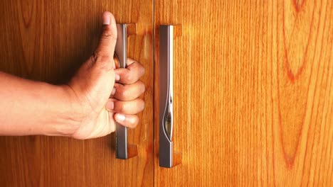 person opening a wooden wardrobe door