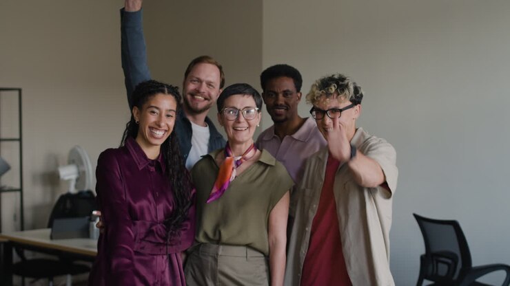 A diverse group of smiling colleagues in an office setting.