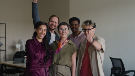 a diverse group of smiling colleagues in an office setting.