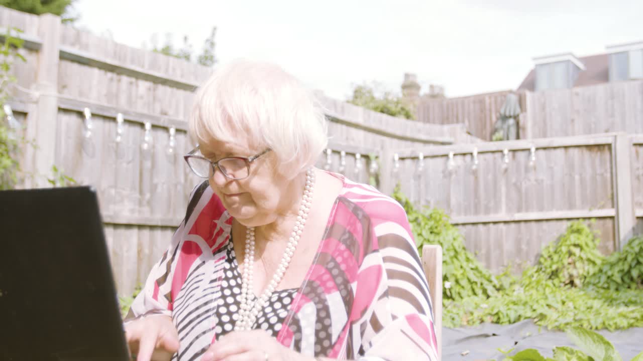 그녀는 노트북에 입력할 때 할머니에게 가까이 다가가고 입력할 때 좌절감을 느낍니다.