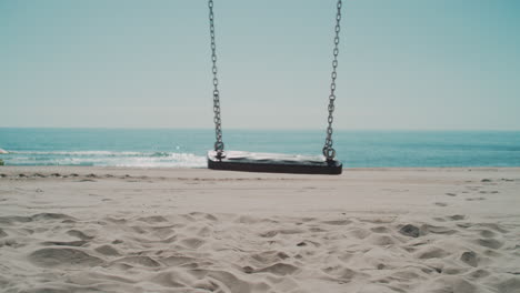 a cradle on the beach with the sea behind on a sunny day