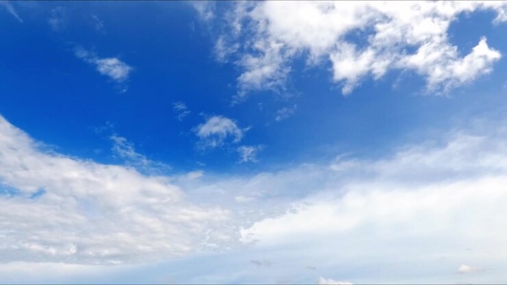 Timelapse di nuvole cumulo bianche che si muovono in un cielo azzurro brillante, catturando il movimento naturale del tempo e un paesaggio atmosferico sereno.