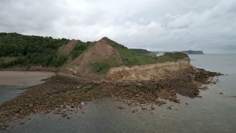 drone aéreo disparado sobre cayton bay, scarborough en la distancia, north yorkshire en un día nublado