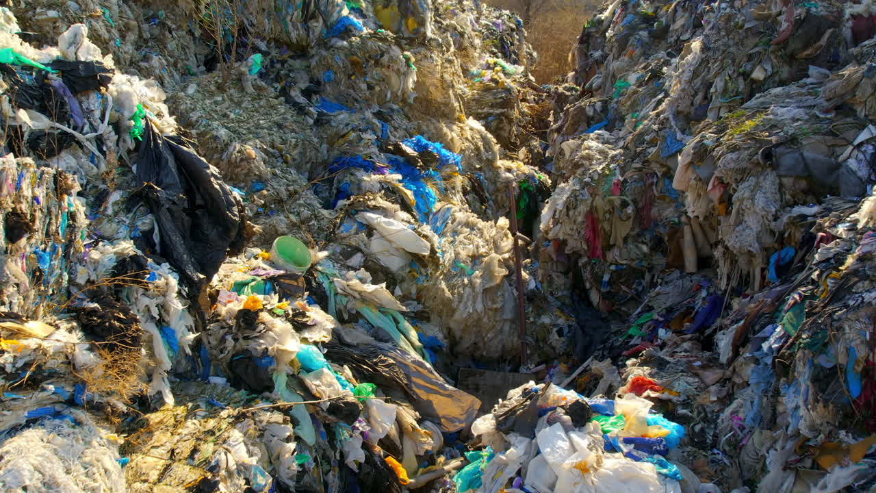 Drone view of huge heaps of pressed garbage at waste sorting plant. Slow motion