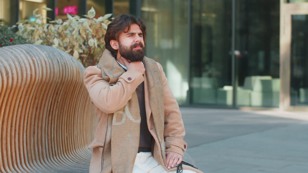 Ill sick indian business man suffering from sore throat put hand on neck season epidemic flu virus