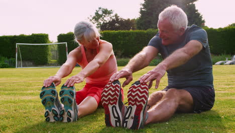 healthy senior couple exercising in garden together