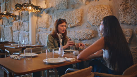 dos mujeres teniendo una conversación en un restaurante