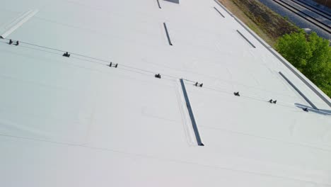 white rooftop insulation panels on top of sports hall beside railroad close up