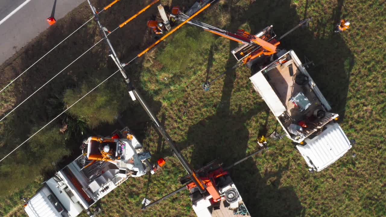 Construction site with people replacing pole for power line, renovation of electricity grid