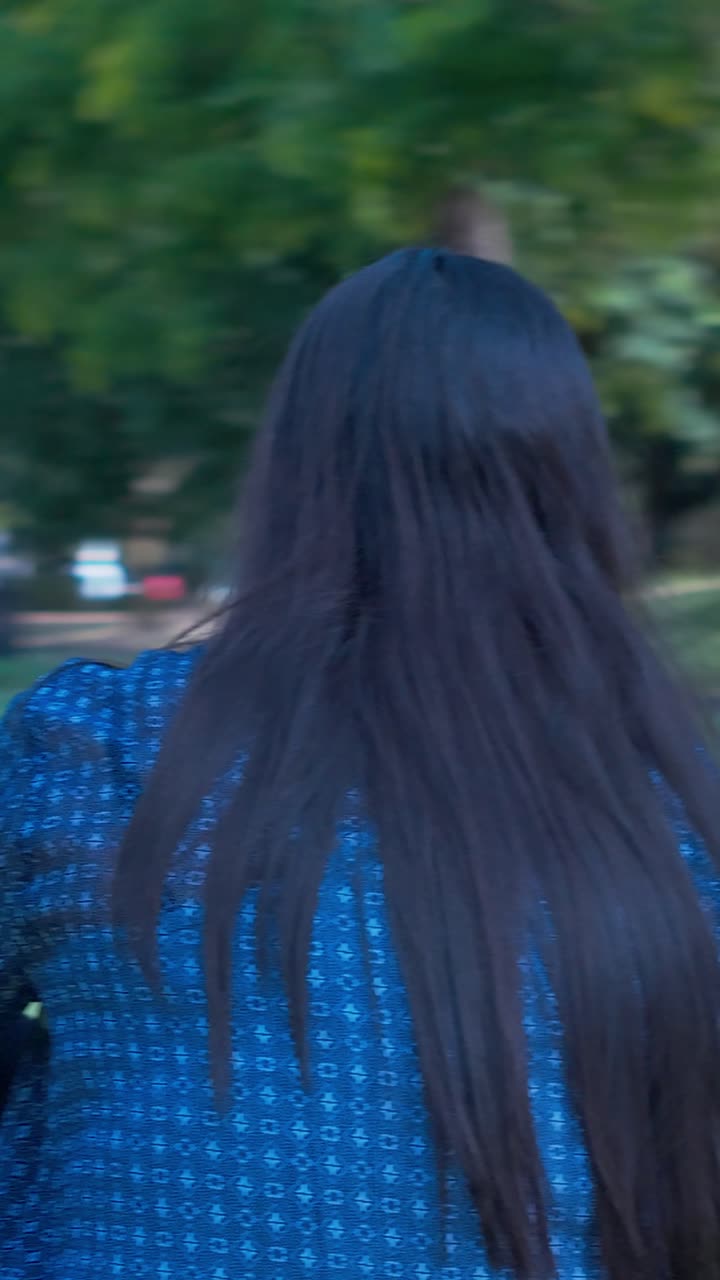 Cattura un momento pensoso mentre una ragazza con gli occhiali da sole si rilassa in una giornata di sole a Croydon Park, Melbourne. Questo video verticale è perfetto per le storie sui social media e per la visualizzazione su dispositivi mobili.
