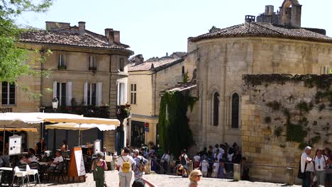 people gather near historic buildings and cafes