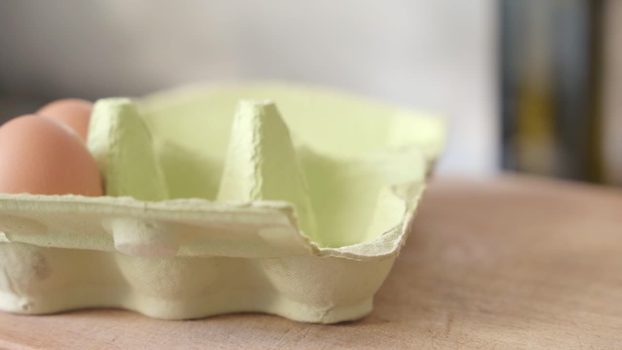 persona que toma huevos de una caja de huevos