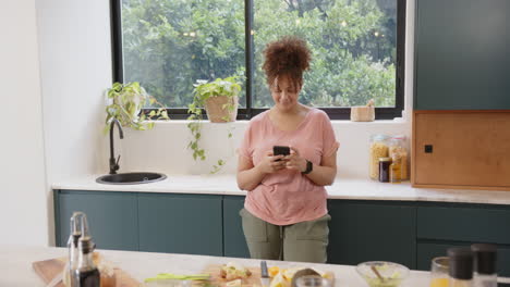 using smartphone, plus size woman preparing healthy meal in modern kitchen