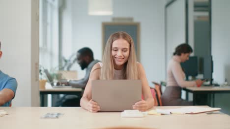 Positive-woman-enjoy-good-news.-Happy-female-freelancer-raising-hands-up