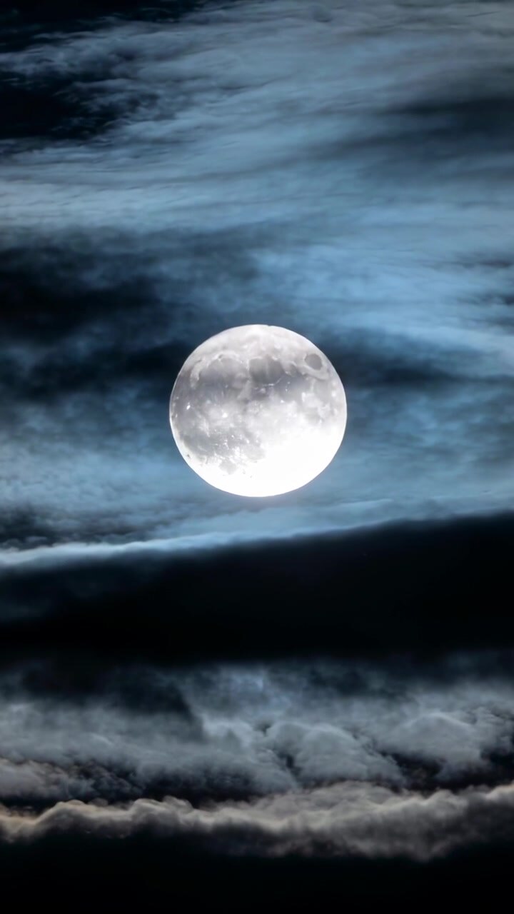 Vídeo vertical: Lua cheia brilhante centrada à noite, nuvens em camadas flutuando, vento velando